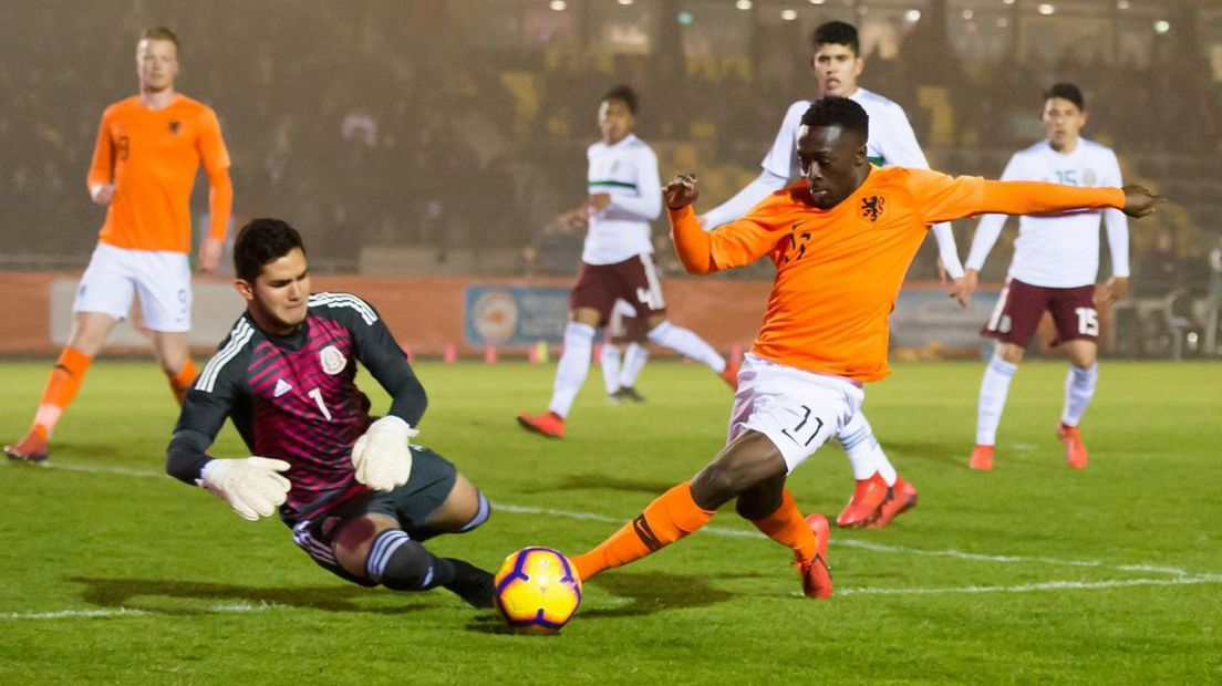 Bobby Adekanye probeert namens Oranje onder 20 jaar de Mexicaanse keeper Carlos Higuera te omspelen