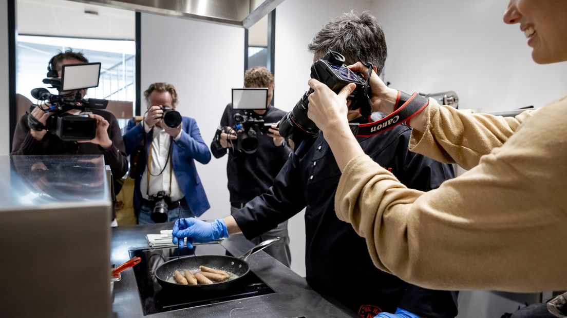 Onder belangstelling van fotografen wordt kweekvlees gebakken voor de eerste proeverij.