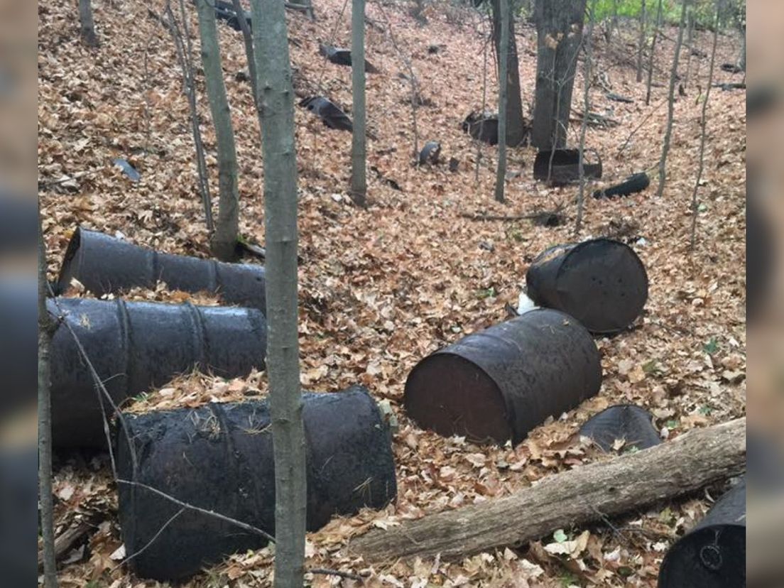 Vaten met PFAS-houdend materiaal liggen in de natuur rondom de Wolverine-fabriek