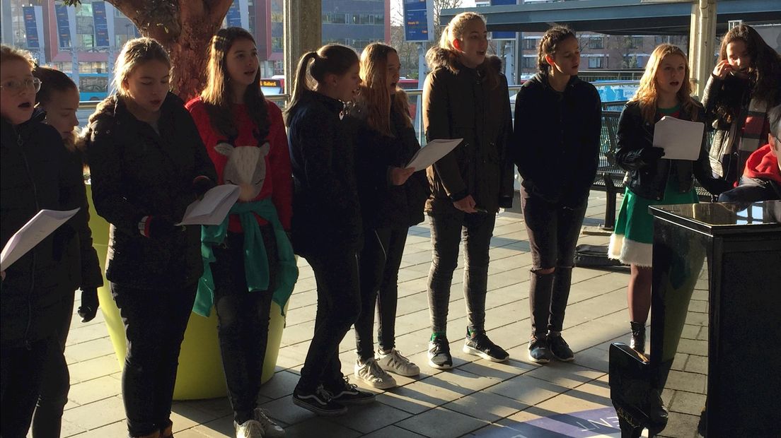 De zingende kinderen en docenten van het Stedelijk Lyceum op station Enschede