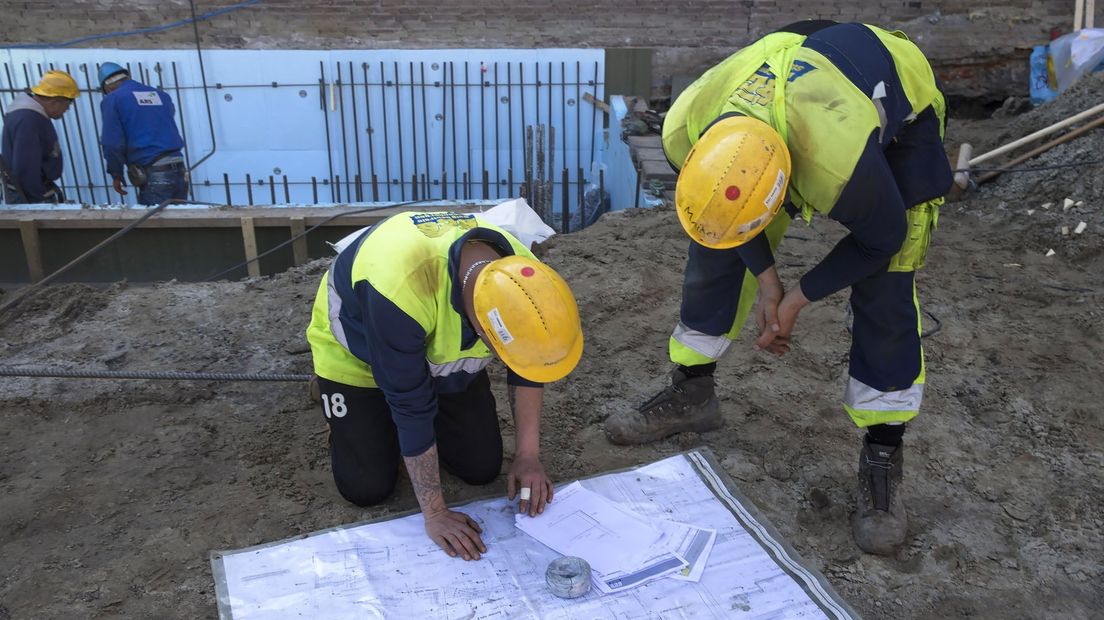 Bouwvakkers buigen zich over het werkplan (foto ter illustratie)