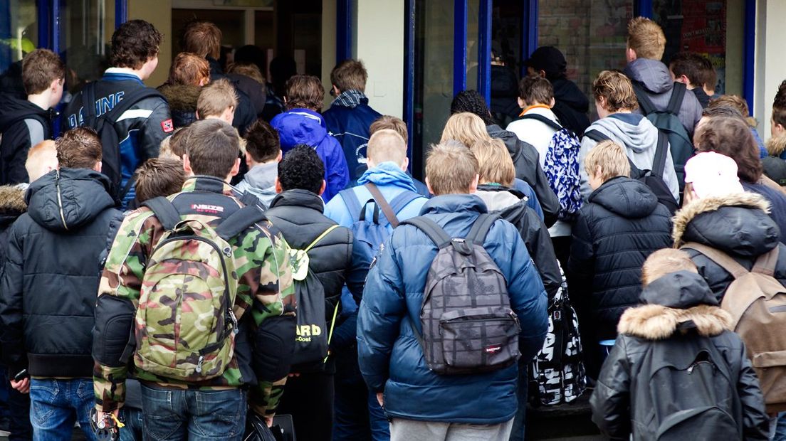 Druk schoolplein, jongeren, schooltassen, school