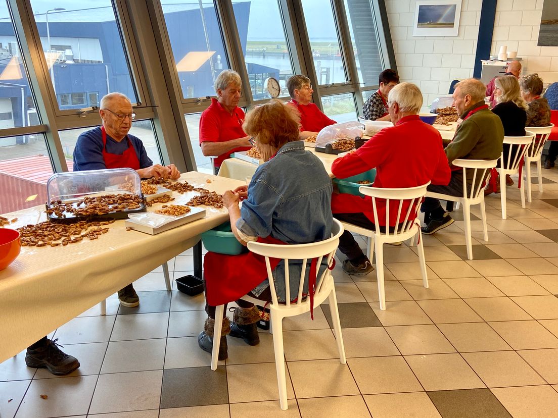 In het handpelatelier pellen vrijwilligers achter elkaar garnalen