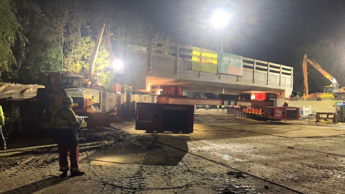 De nieuwe spoorbrug wordt op z'n plek gereden.