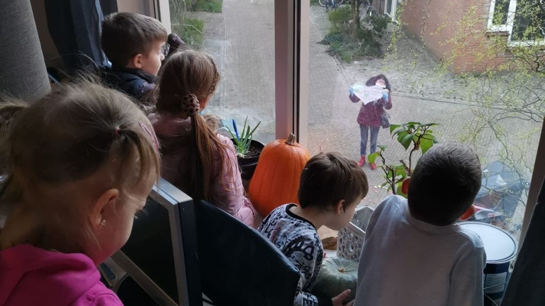 De kleinkinderen kijken vanachter het raam naar 'oma tuin' en haar brandend hart