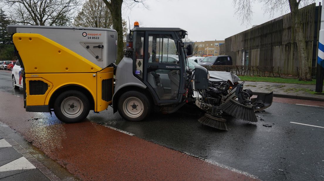 Schade na het ongeluk tussen de veegauto en de personenauto