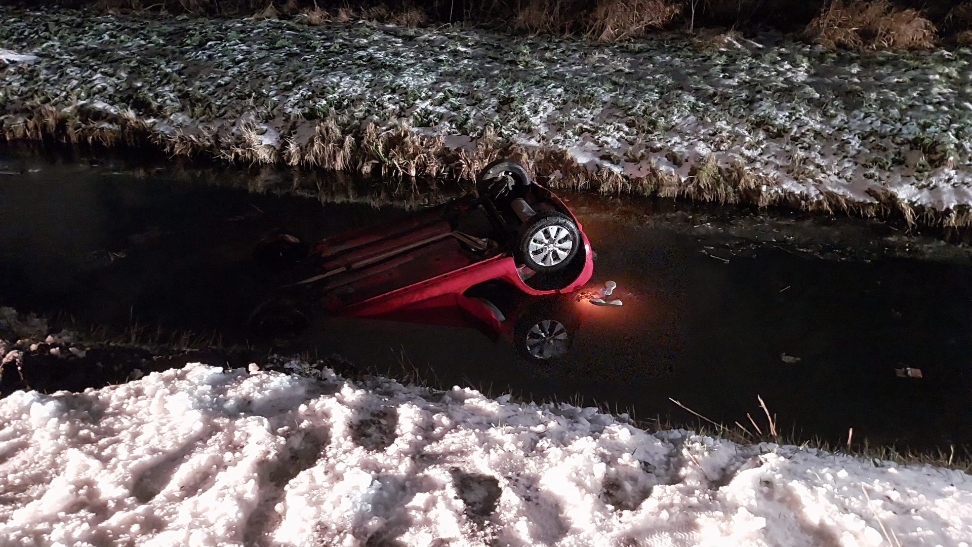 De auto met drie inzittenden kwam ondersteboven in het water terecht.