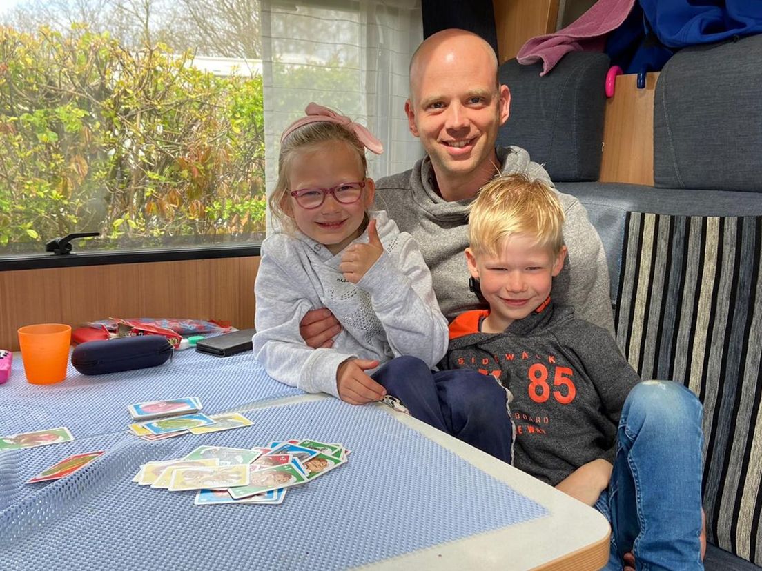 Robin Uebing en zijn kinderen Luna en Stijn laten zich niet kisten door het slechte weer en spelen een kaartspelletje