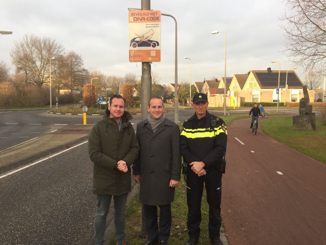 Burgemeester Van Hemmen, wijkagent Hans van Schaik en leverancier Tijmen van den Boogaard bij het nieuwe verkeersbord