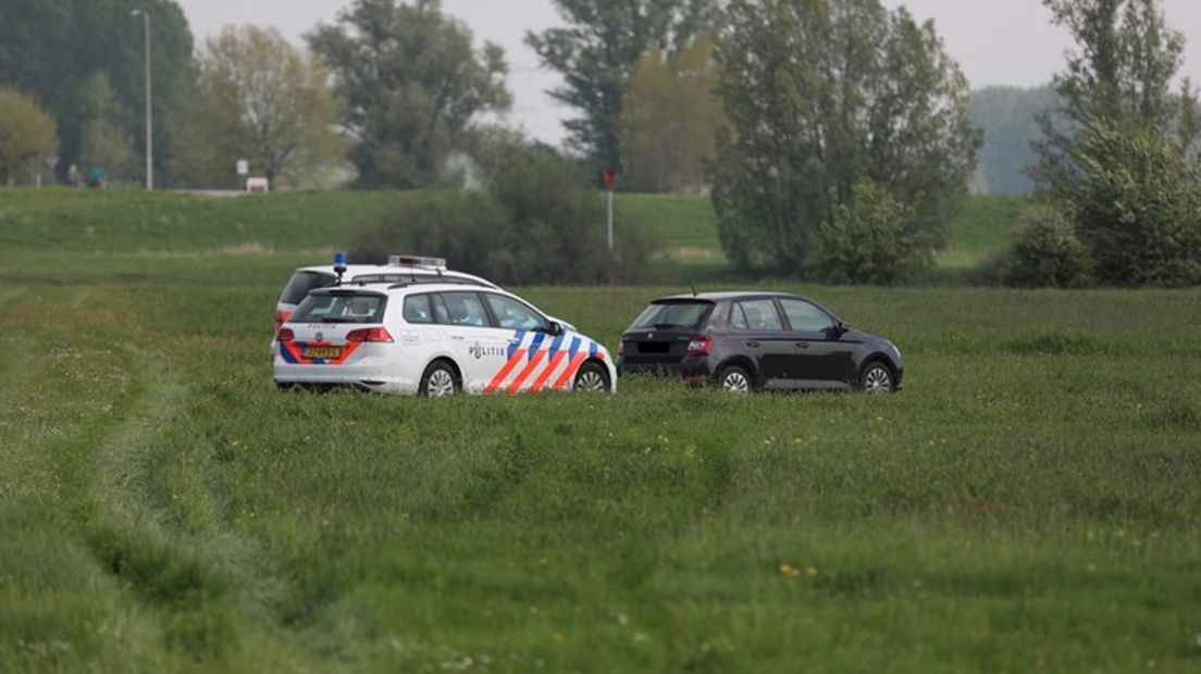 Politiewagens bij de IJssel.