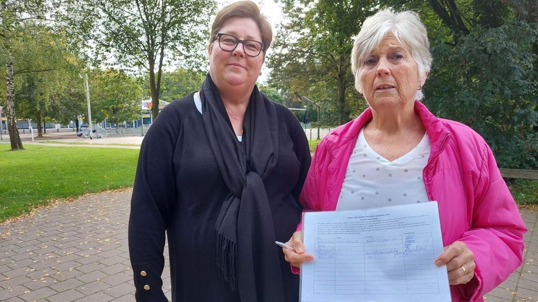 Buurtbewoners Astrid en Elly met de petitie om overlast van groepen jongeren te laten afnemen.