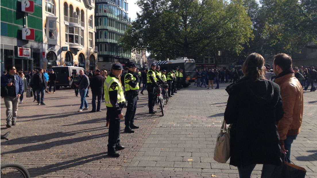 De politie vormt een rij met fietsen om toeschouwers op afstand te houden.