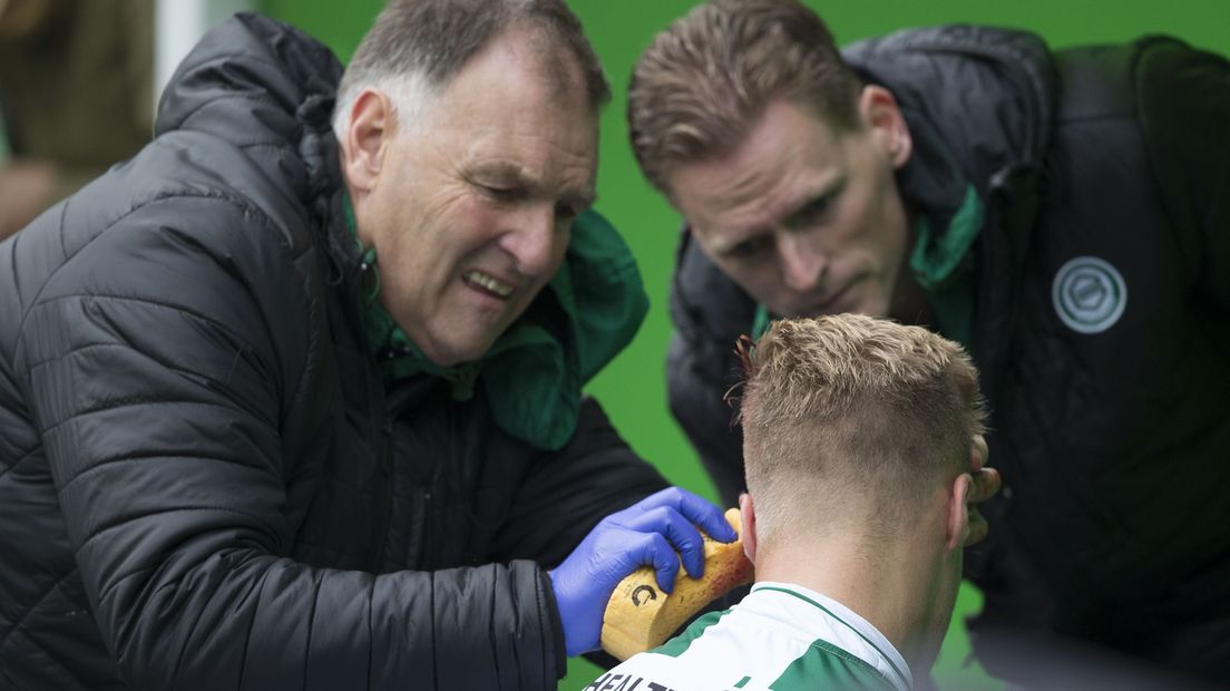 Henk Hagenauw (links) stelpt een hoofdwond