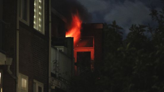Vlammen slaan uit raam bij brand in appartement