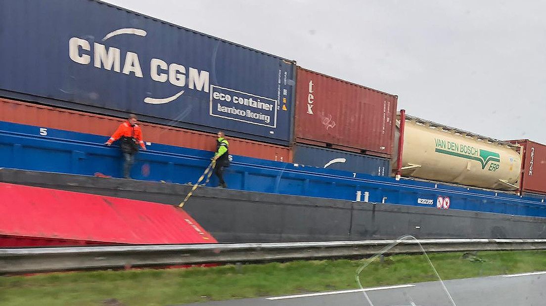 Opvarenden van het schip ontfermen zich over de gevallen container