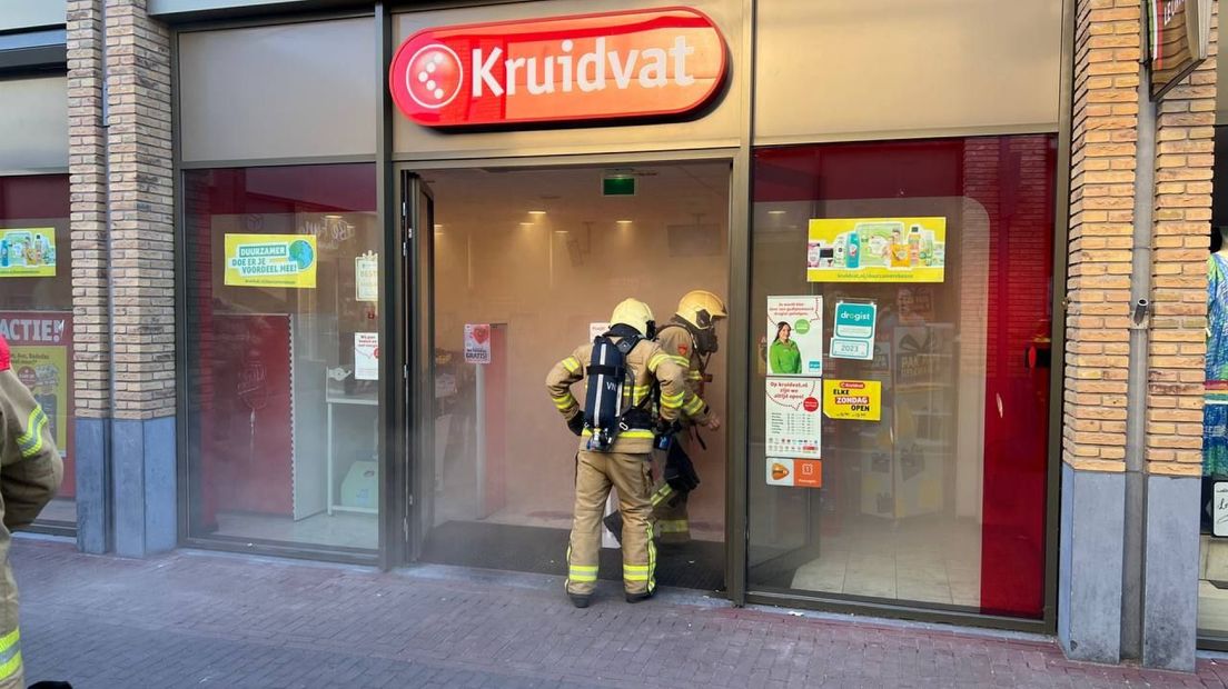 Brandweermedewerkers treden de winkel in Ulft binnen.