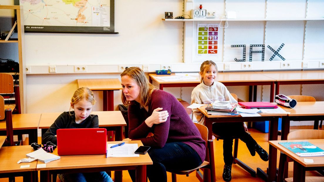 Een lerares en leerlingen op de basisschool