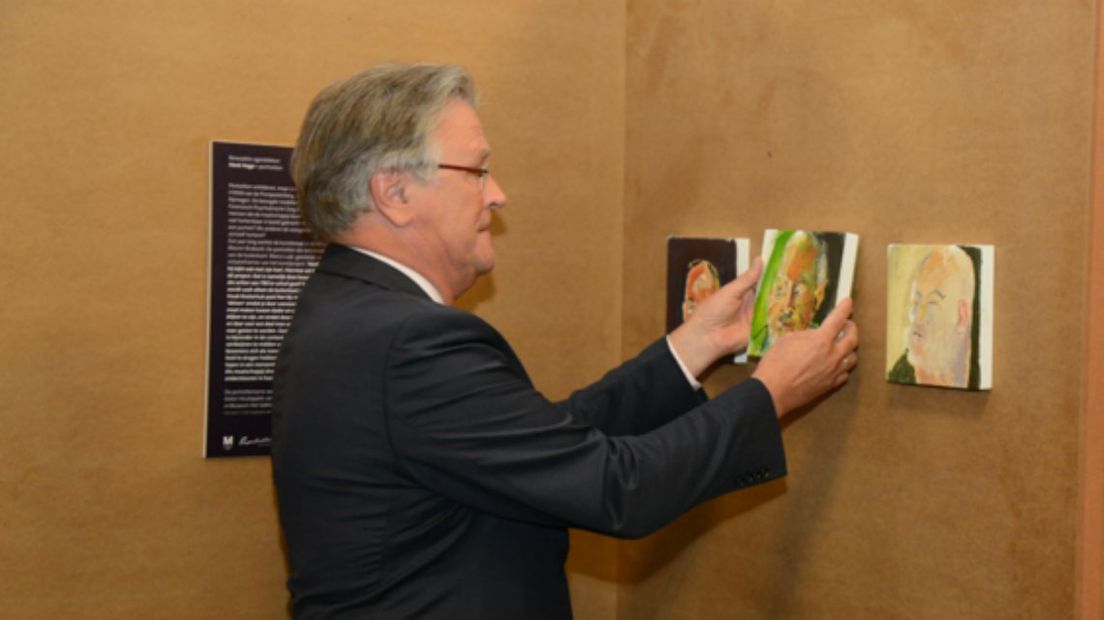 Siebe Riedstra,  secretaris-generaal bij het ministerie van Veiligheid en Justitie, verricht met het hangen van het laatste portret de openingshandeling