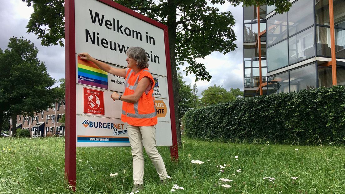 De Nieuwegeinse wethouder Marieke Schouten plakte een regenboogvlag over de Poolse stad Pulawy op het welkomstbord.