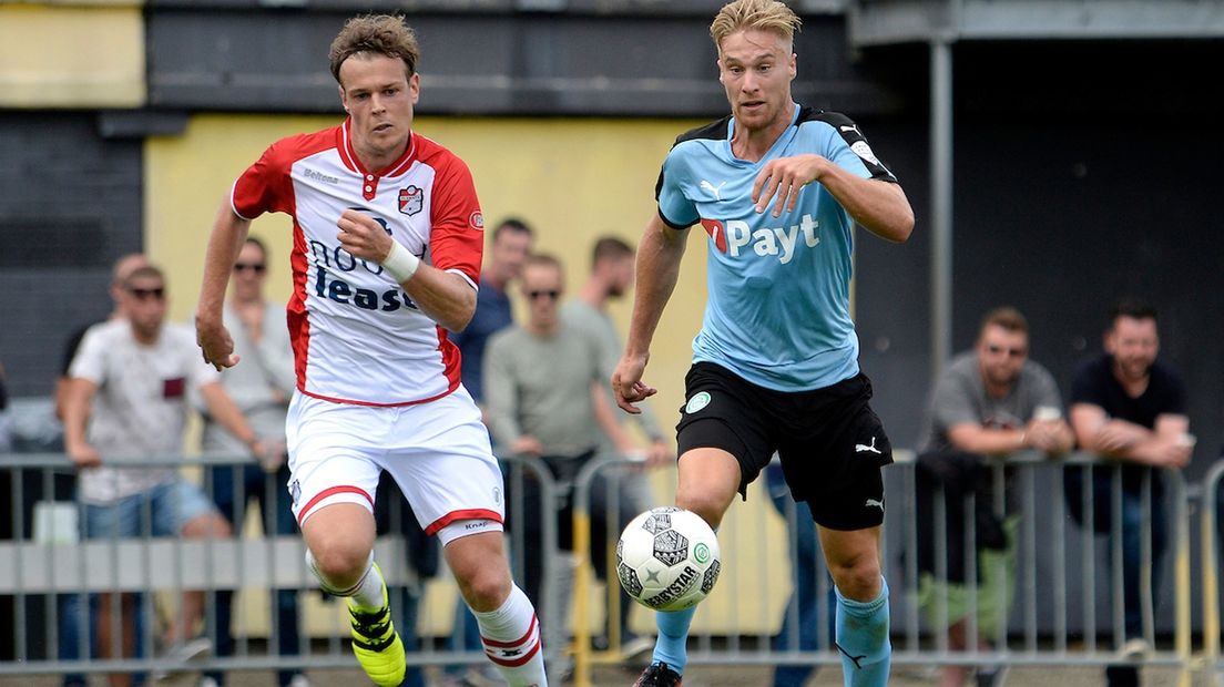 Jeroen Veldmate (links) duelleert in een oefenduel om de bal met Tom van Weert (FC Groningen)