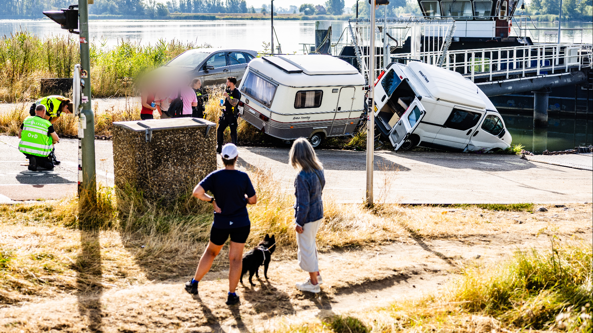 De auto met de caravan reed van het talud af.