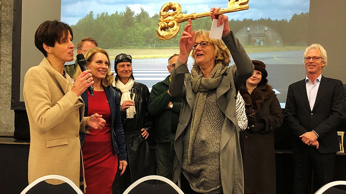 Gedeputeerde Maasdam doet de overdracht.