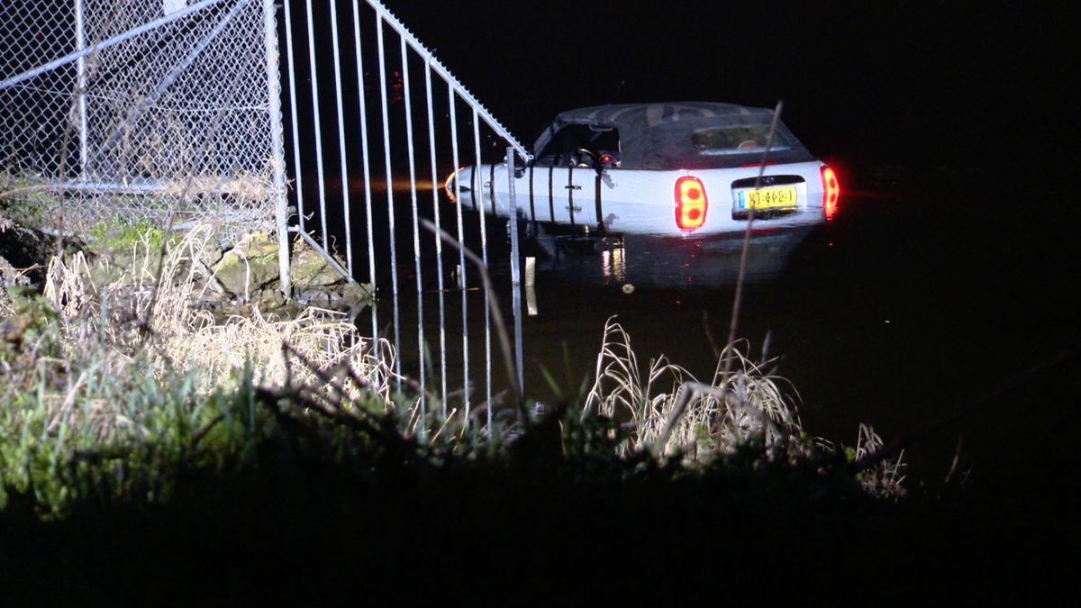 Auto glijdt van helling af en rijdt de Maas in bij Herten