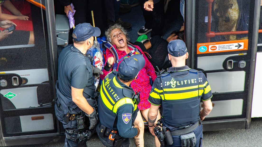 Agenten dragen een activist naar de arrestantenbus