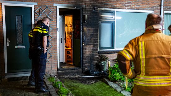 Gevel zwartgeblakerd en gat in deur na mogelijke explosie