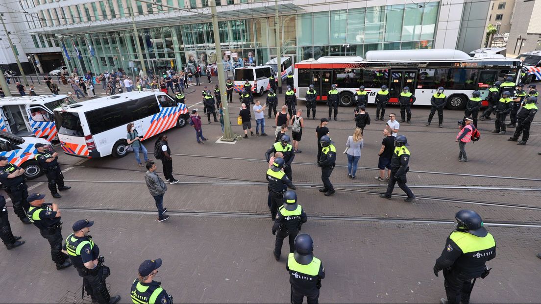 De betogers zijn omsingeld en worden afgevoerd in een bus.