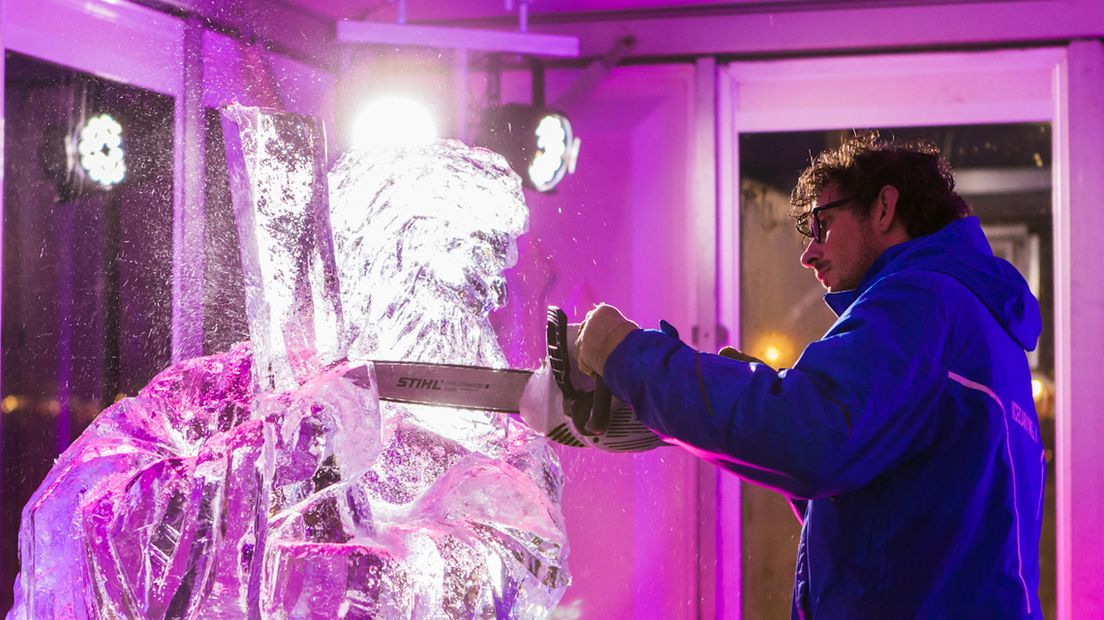 Een ice carver werkt aan een ijssculptuur 