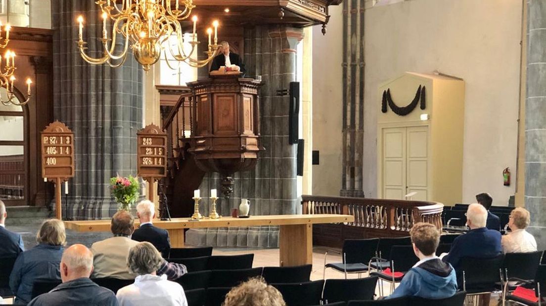 Kerkgangers luisteren naar de predikant