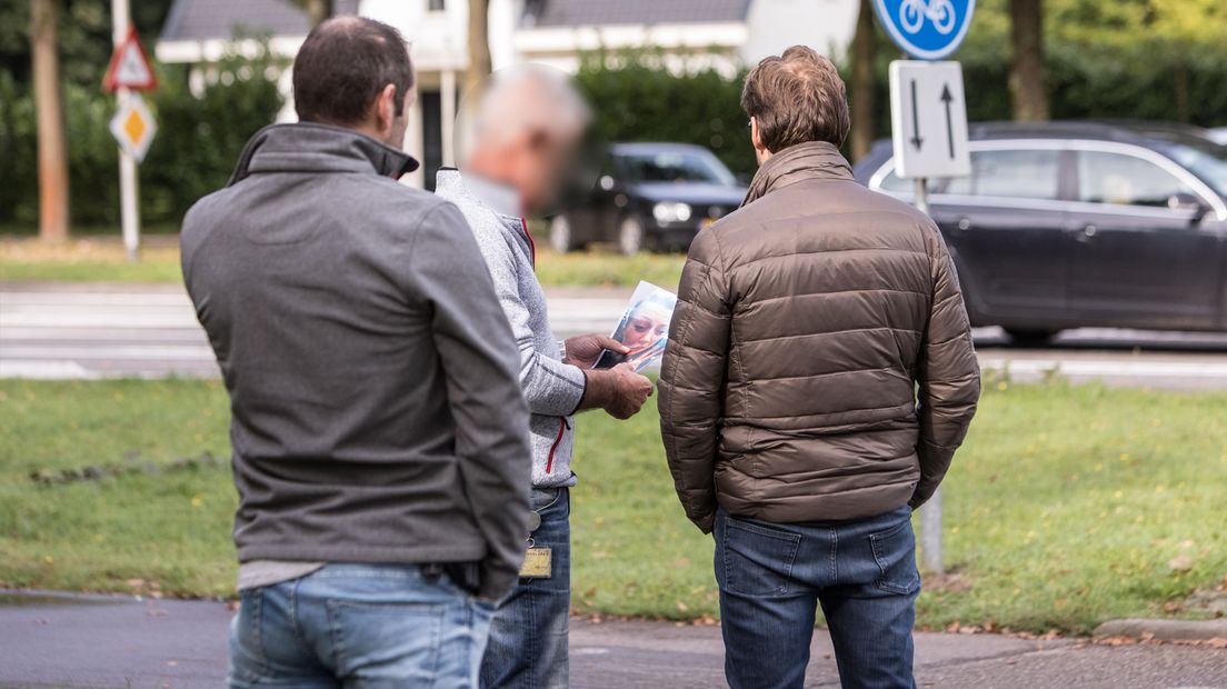 De rechercheurs, die niet herkenbaar op beeld willen, praten met de vader van Anne (bruine jas).