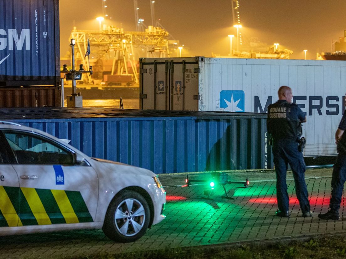 Twee medewerkers van de douane bekijken de drone voordat deze opstijgt in de Rotterdamse haven.