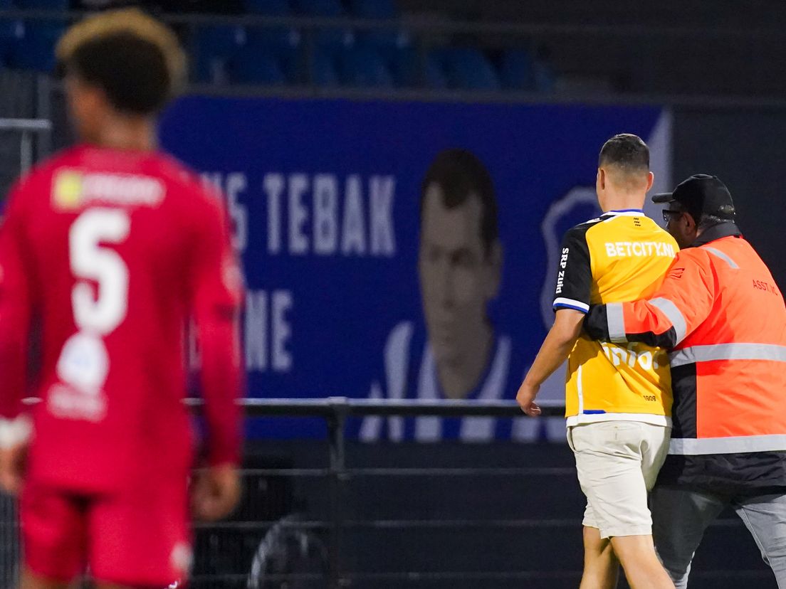 Een steward haalt een toeschouwer van het veld tijdens FC Eindhoven-FC Dordrecht