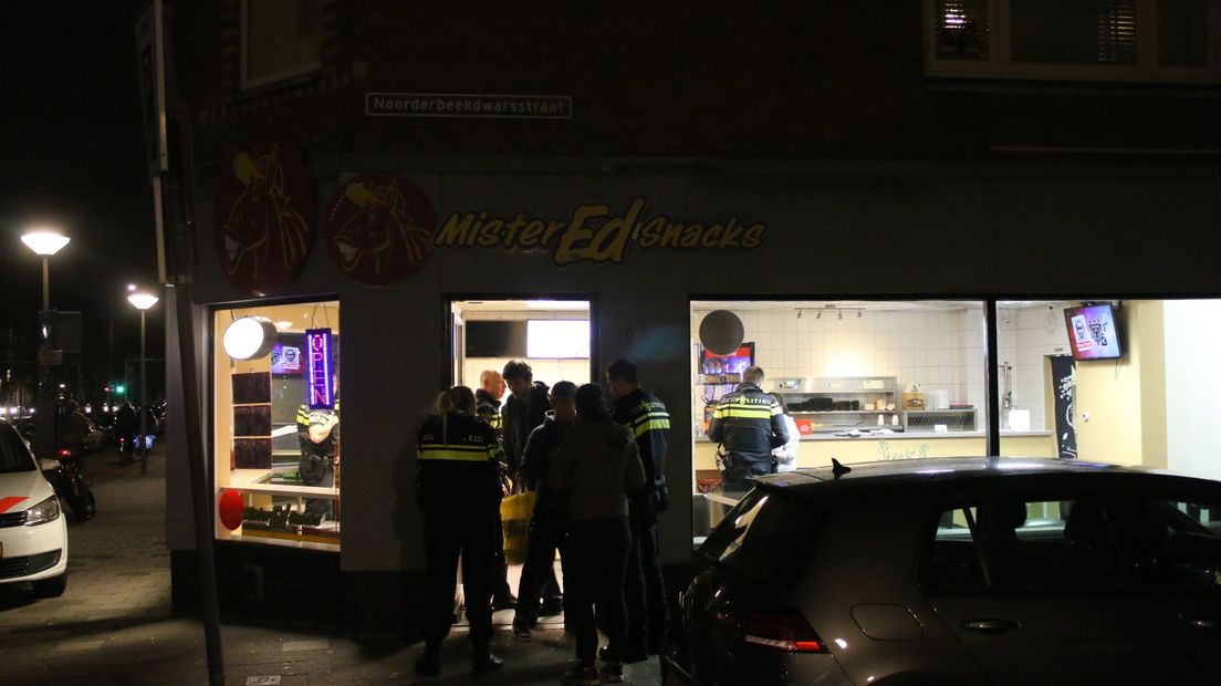 Politieagenten doen onderzoek bij Mister Ed Snacks in Den Haag