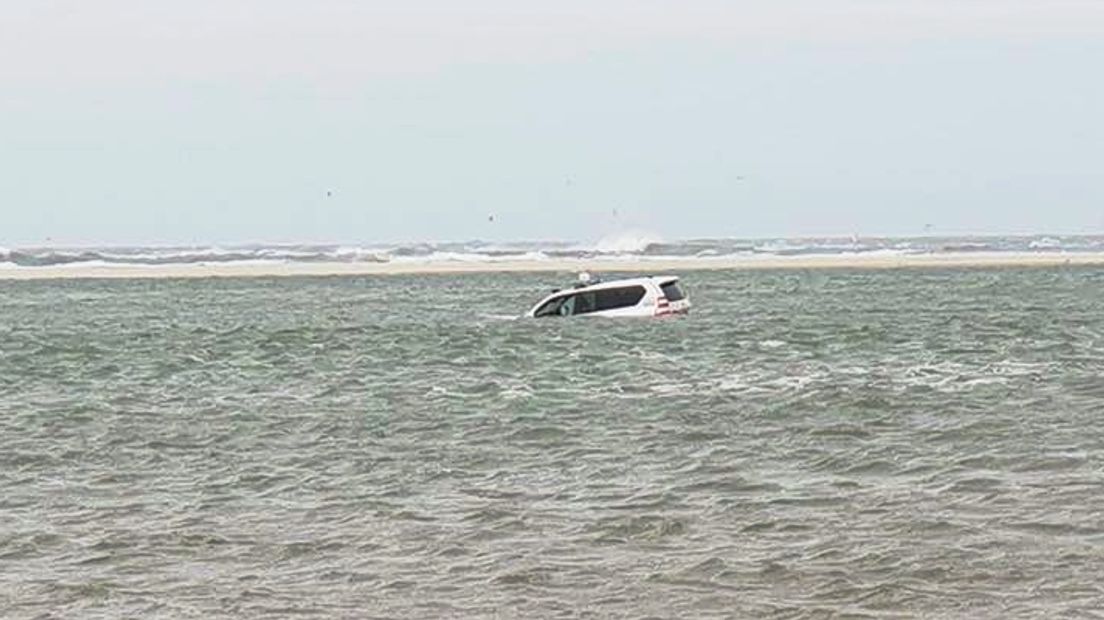 Politieauto vast in zee bij reddingsactie