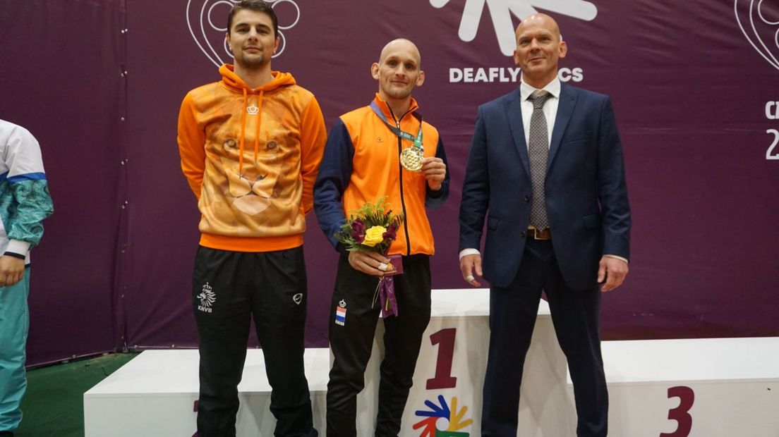 Judoka Albert Westerhof (midden) met goud op de Deaflympics. Rechts trainer Wietse Swart