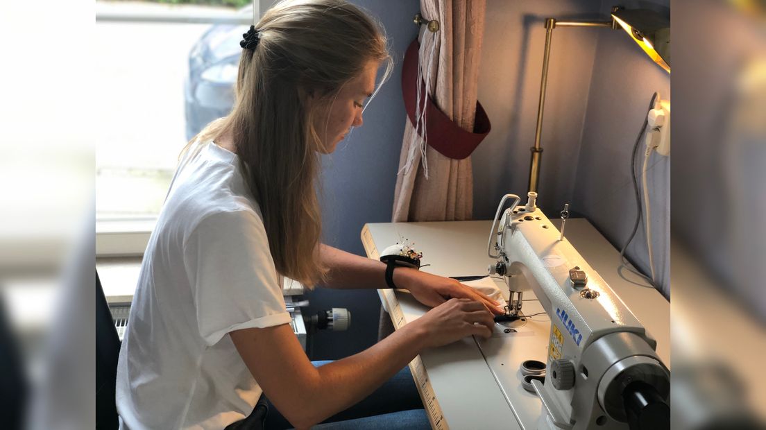 Lara Zwaan maakt mondkapjes met haar naaimachine in Biggekerke.