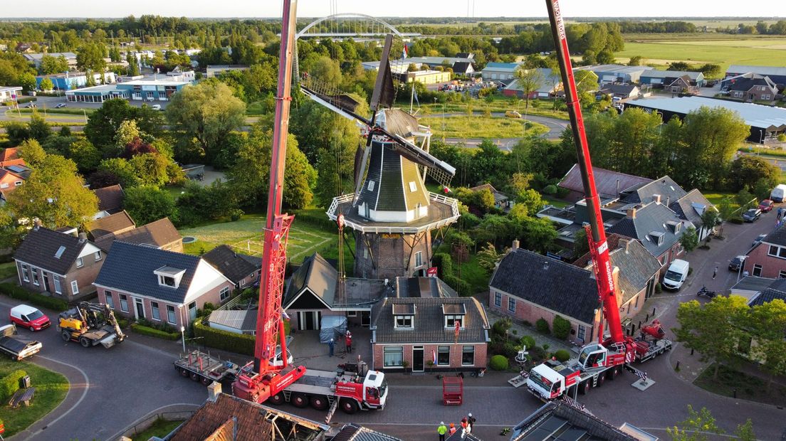 Met behulp van twee kranen worden de wieken naar beneden gehaald