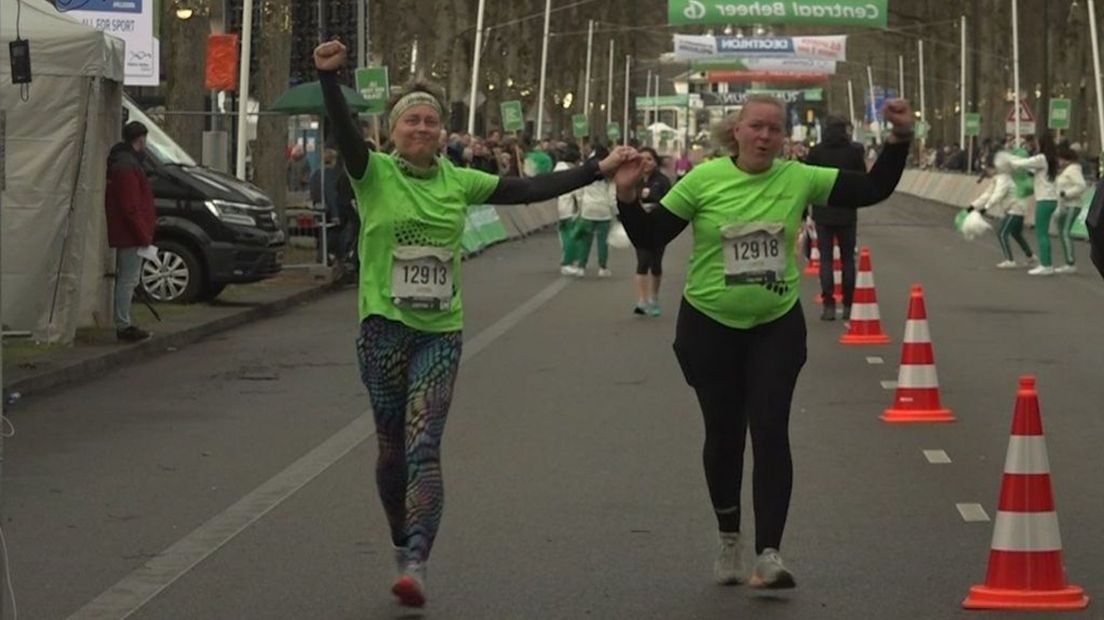 Juichend komen deelnemers aan de Midwintermarathon over de finish.