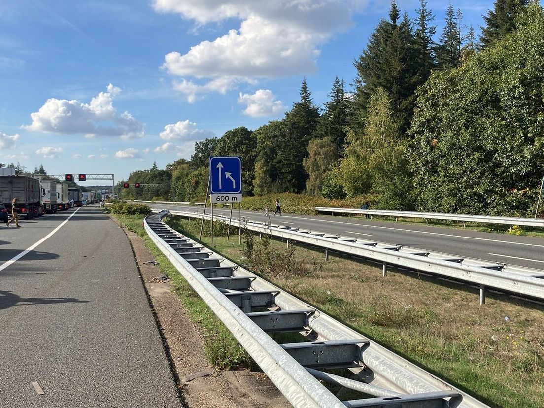 De weg waar de A50 overgaat in de A12 is dicht. Mensen lopen daar over de weg.