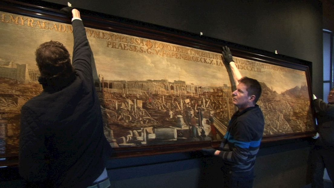 Het schilderij "Gezicht op Palmyra" wordt opgehangen in de Waag