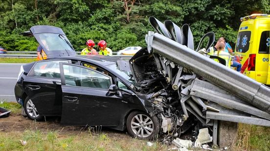 Automobilist vast onder vangrail op A50