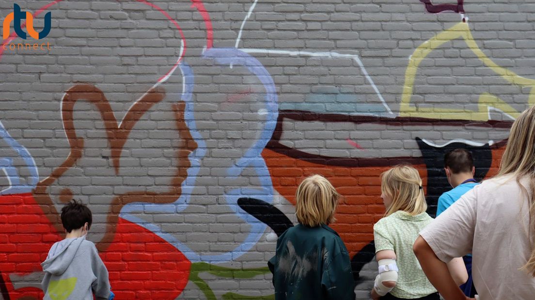 Jongeren bekijken de muurschildering