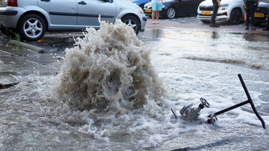 Waterleiding breekt tijdens blussen woningbrand, waterfontein uit grond zet straten blank Home