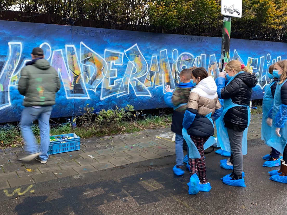 Kinderen maken graffitibord tegen kindermishandeling