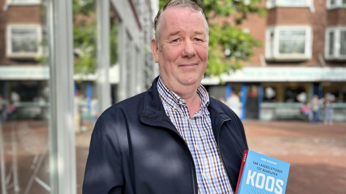Koos Vervoort met zijn boek vóór het Glazen Radiohuis