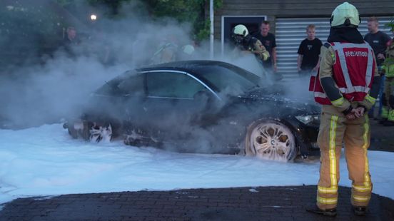 Jongeren trekken brandende auto weg bij huis met rieten dak in Staphorst