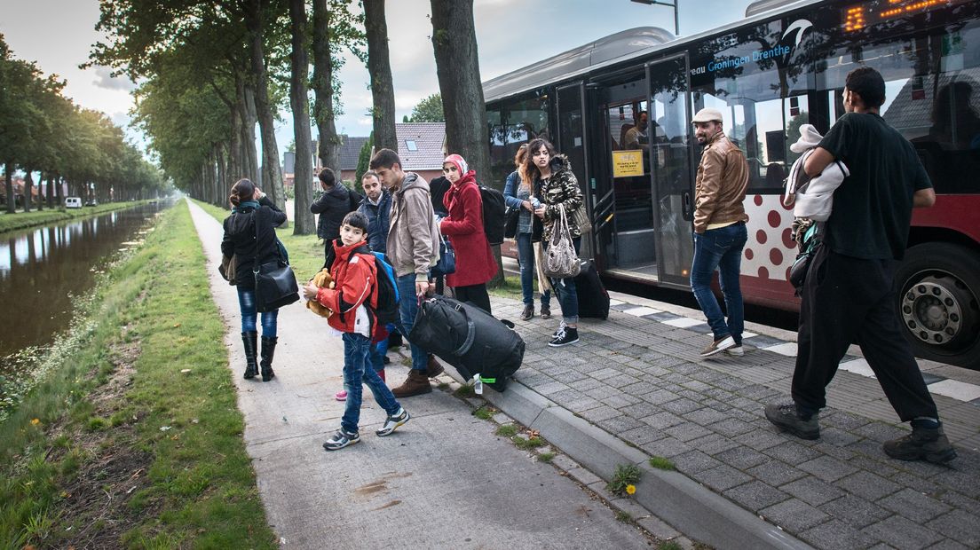 Vluchtelingen stappen uit lijnbus 73 in Ter Apel